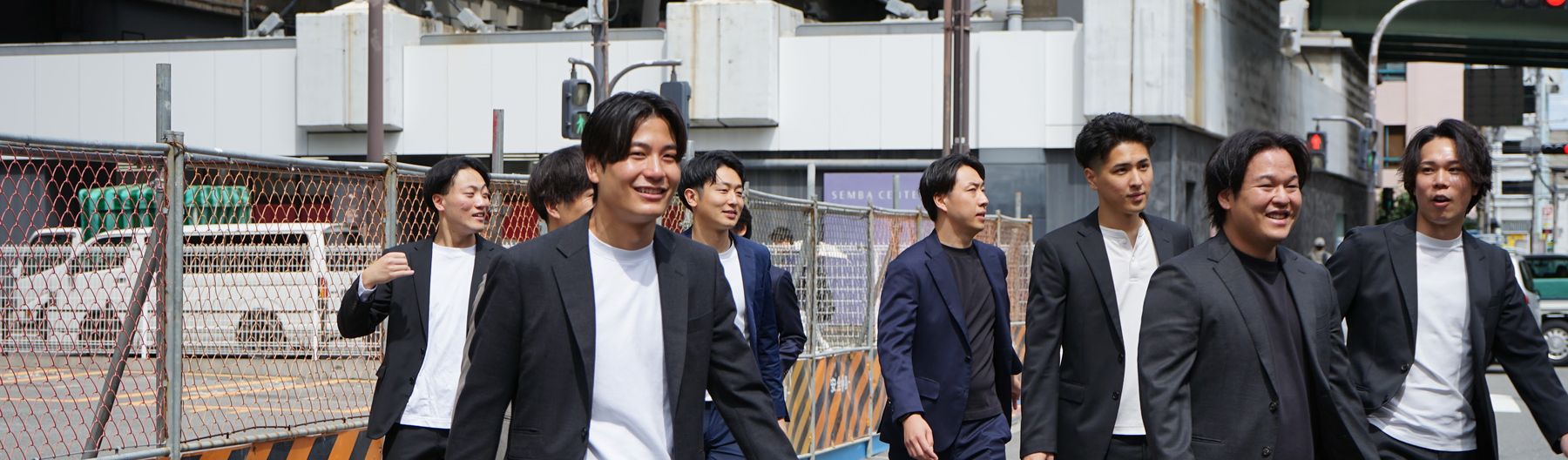 高架下の通りを並んで歩く株式会社Remindのメンバー