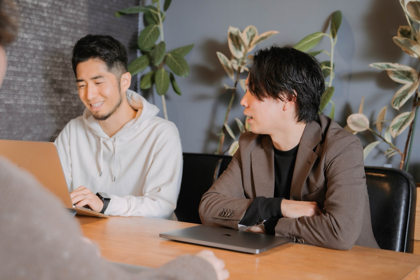 机をはさんで話し合う株式会社Remindのメンバー