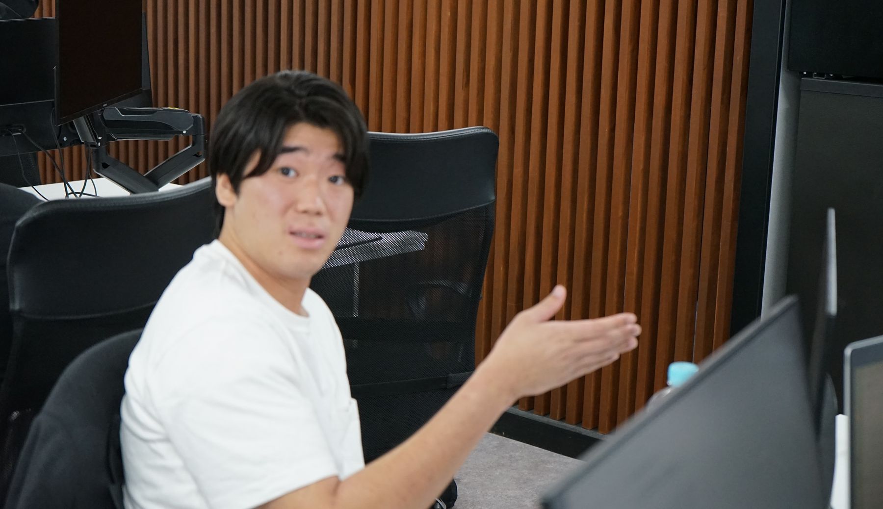 デスクでモニターを指しながら話す株式会社Remindのメンバー