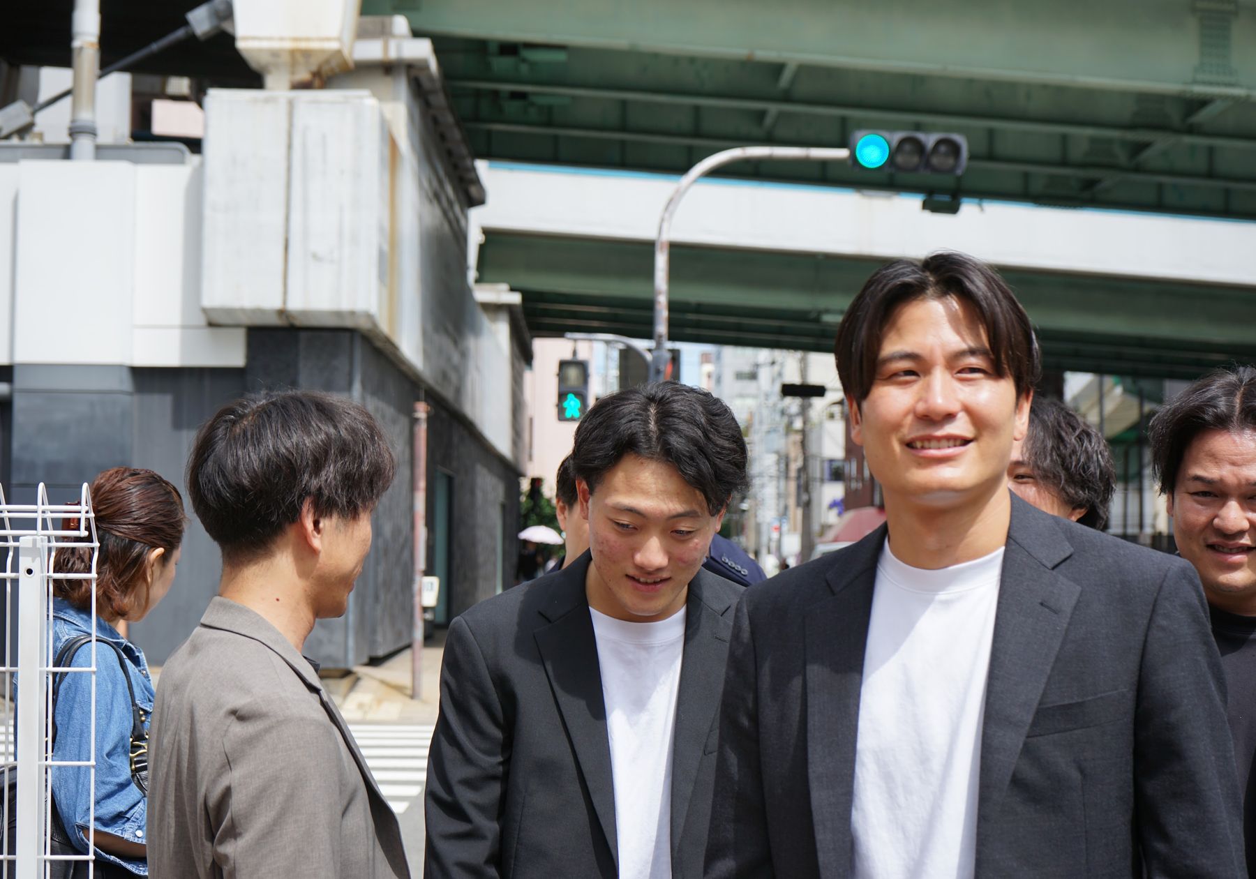 街角で笑いながら並ぶ株式会社Remindのメンバー