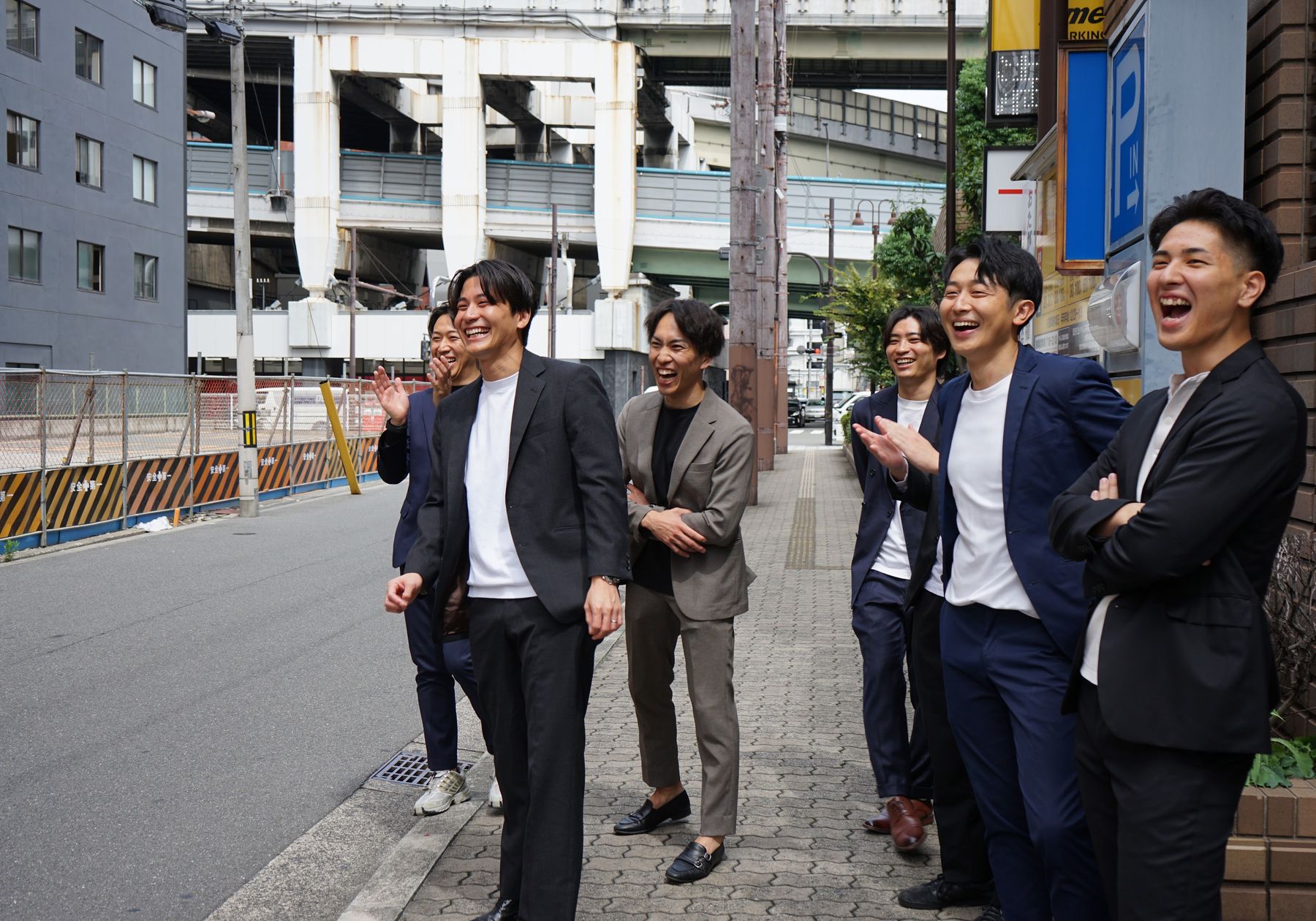 街角で笑いながら集まる株式会社Remindのメンバー
